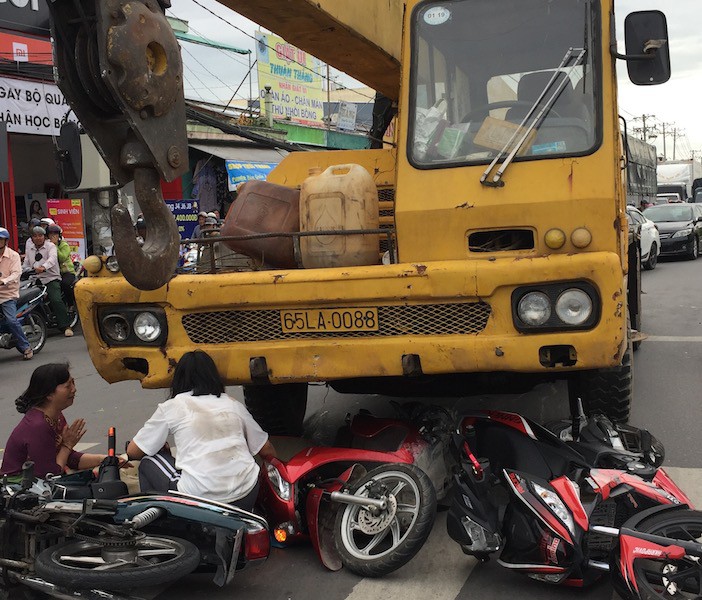 Xe cẩu tông 3 xe máy dừng đèn đỏ, 1 bé trai tử vong