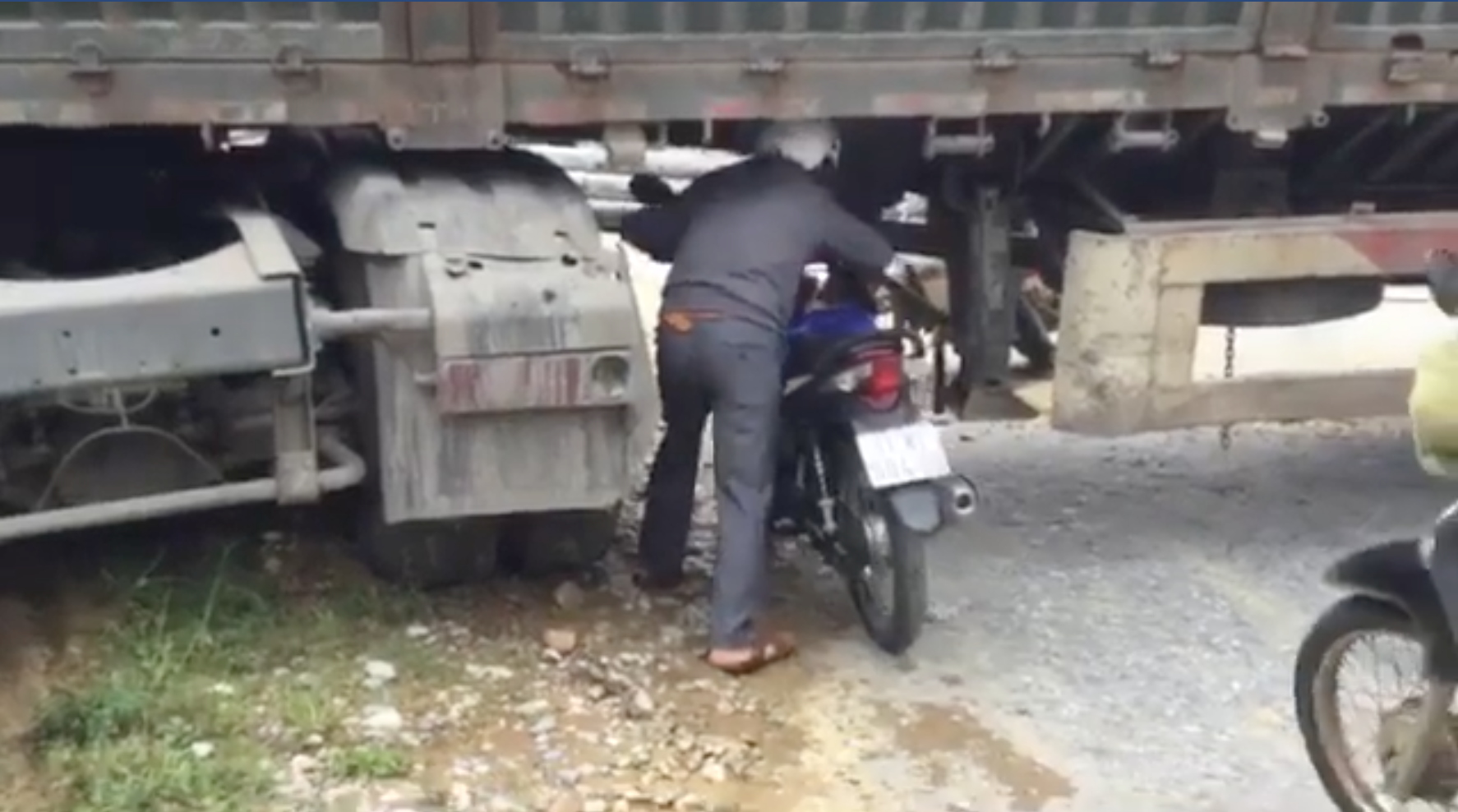 Xe chở cột điện chắn ngang quốc lộ, dân chui gầm xe qua đường
