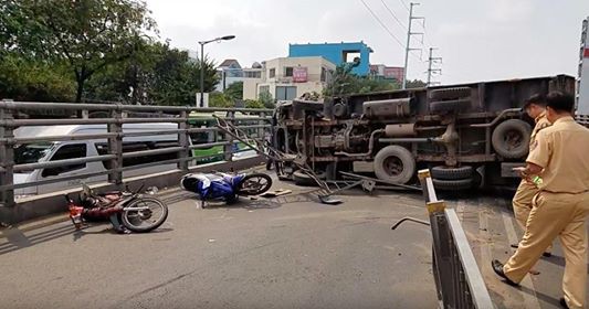 Xe tải lật nh&agrave;o, nhiều người g&agrave;o kh&oacute;c vứt phương tiện bỏ chạy - Ảnh 1.