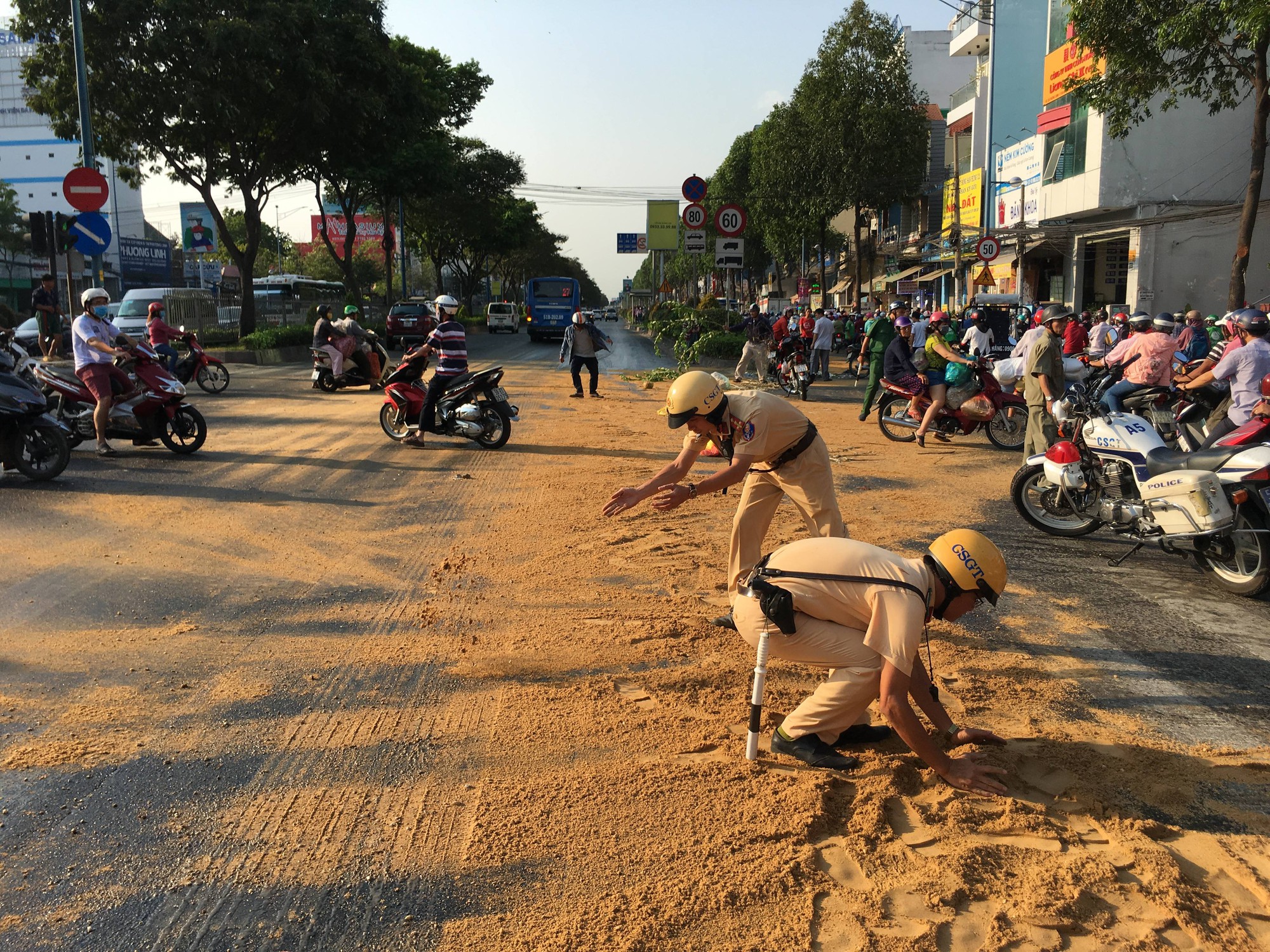 Hoá chất đổ đầy đường, người dân cùng CSGT lom khom phủ cát