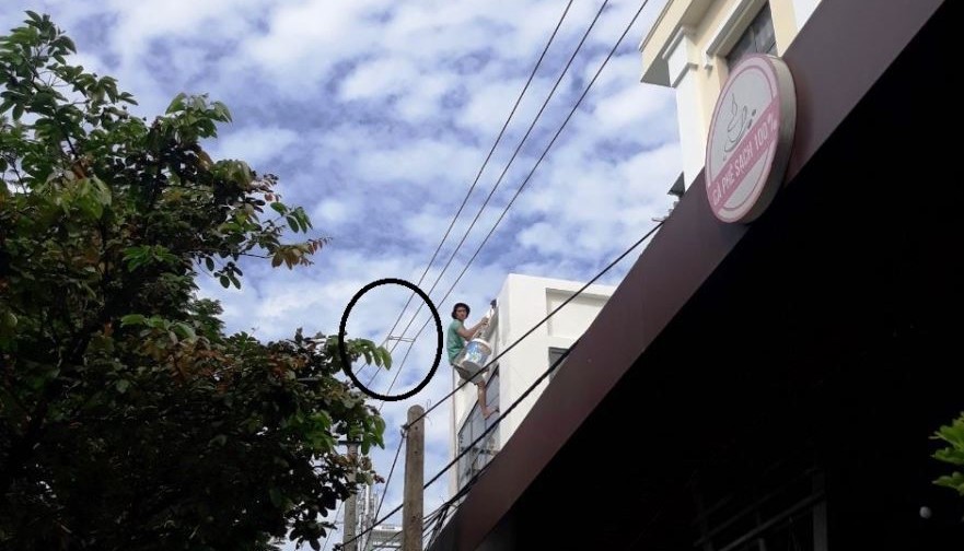 Thợ sơn liều lĩnh buộc 3 dây điện trung thế để tiện sơn vôi mặt tiền