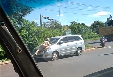 CLIP: Cảnh s&aacute;t giao th&ocirc;ng đu m&igrave;nh tr&ecirc;n nắp ca-p&ocirc; &ocirc;t&ocirc; - Ảnh 1.