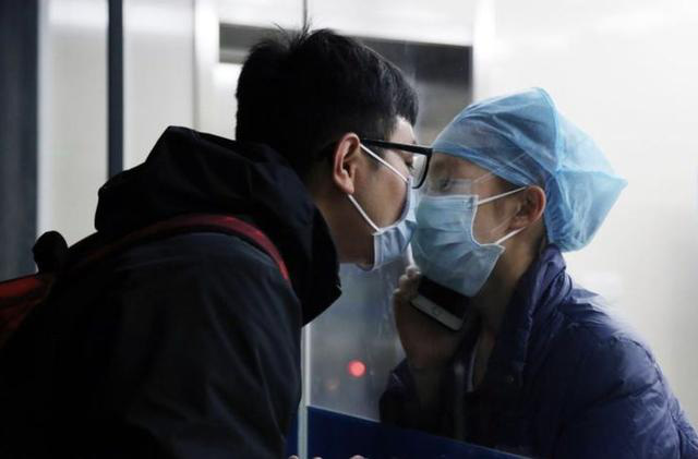 Giữa đại dịch virus corona, nữ y tá hôn bạn trai qua tấm kính cách ly