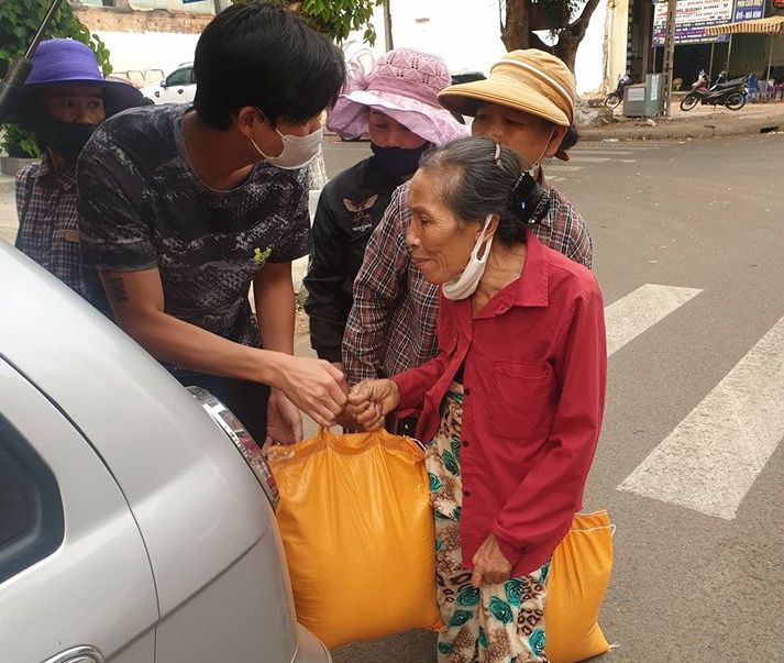 Hai người đàn ông"chạy vòng vòng" phát gạo cho người bán vé số