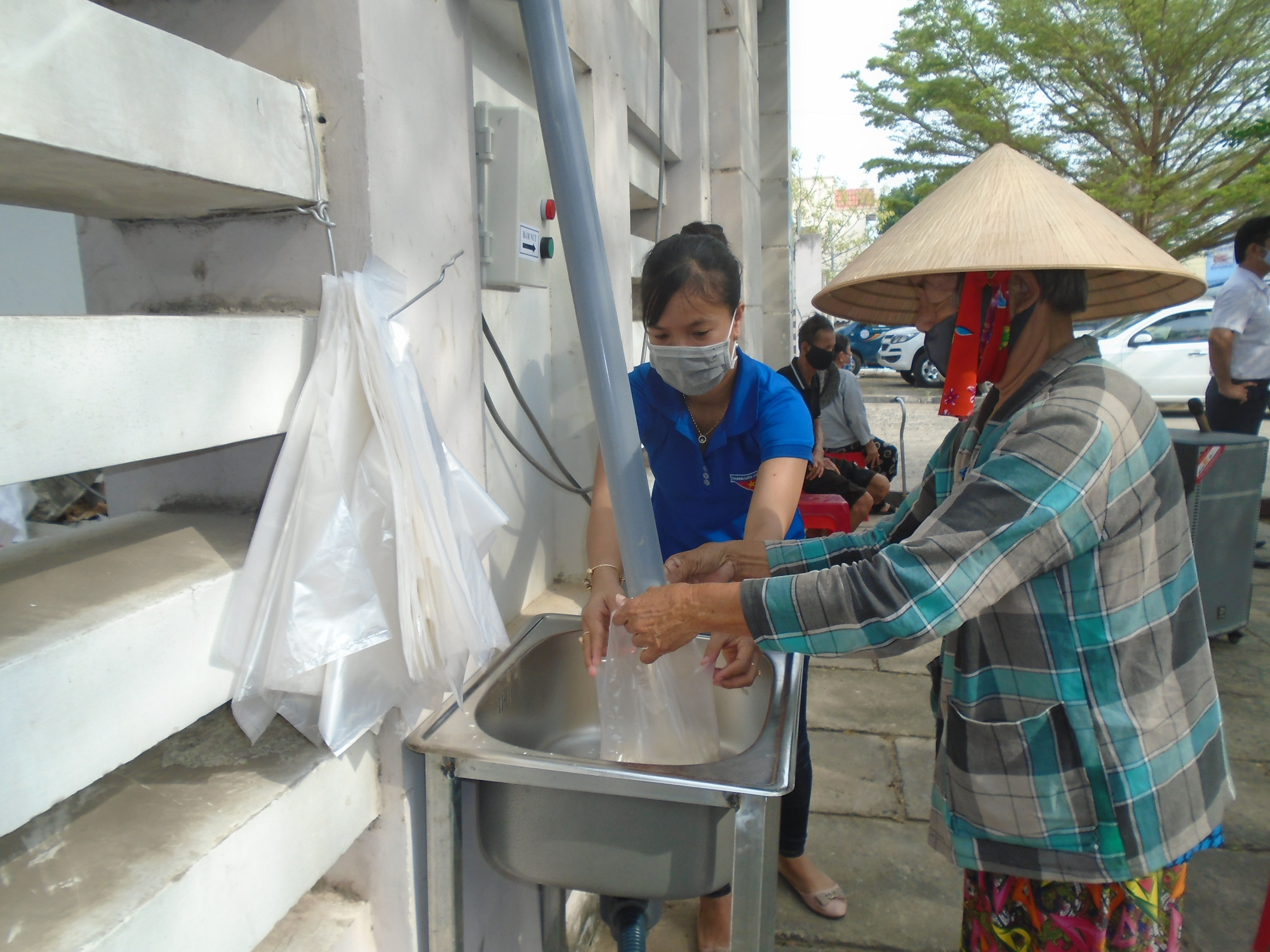 H&igrave;nh 2 Sau khi đưa phiếu để kiểm tra, b&agrave; con chỉ cần ấn n&uacute;t để nhận mỗi phần 2kg gạo