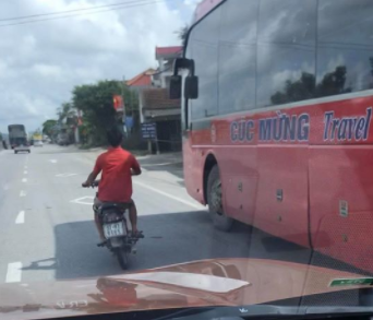 CLIP: Người đàn ông đi xe máy lạng lách, đánh võng trước đầu ôtô, chạy vào đường ngược chiều - Ảnh 2.