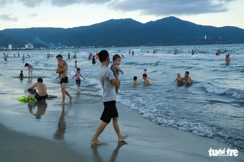 Biển Đ&agrave; Nẵng đ&ocirc;ng đ&uacute;c trở lại sau nhiều ng&agrave;y vắng b&oacute;ng người - Ảnh 1.