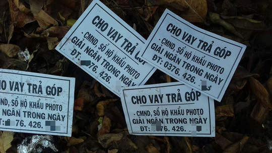 Hai thanh ni&ecirc;n đi rải tờ rơi lộ tội cho vay nặng l&atilde;i - Ảnh 1.