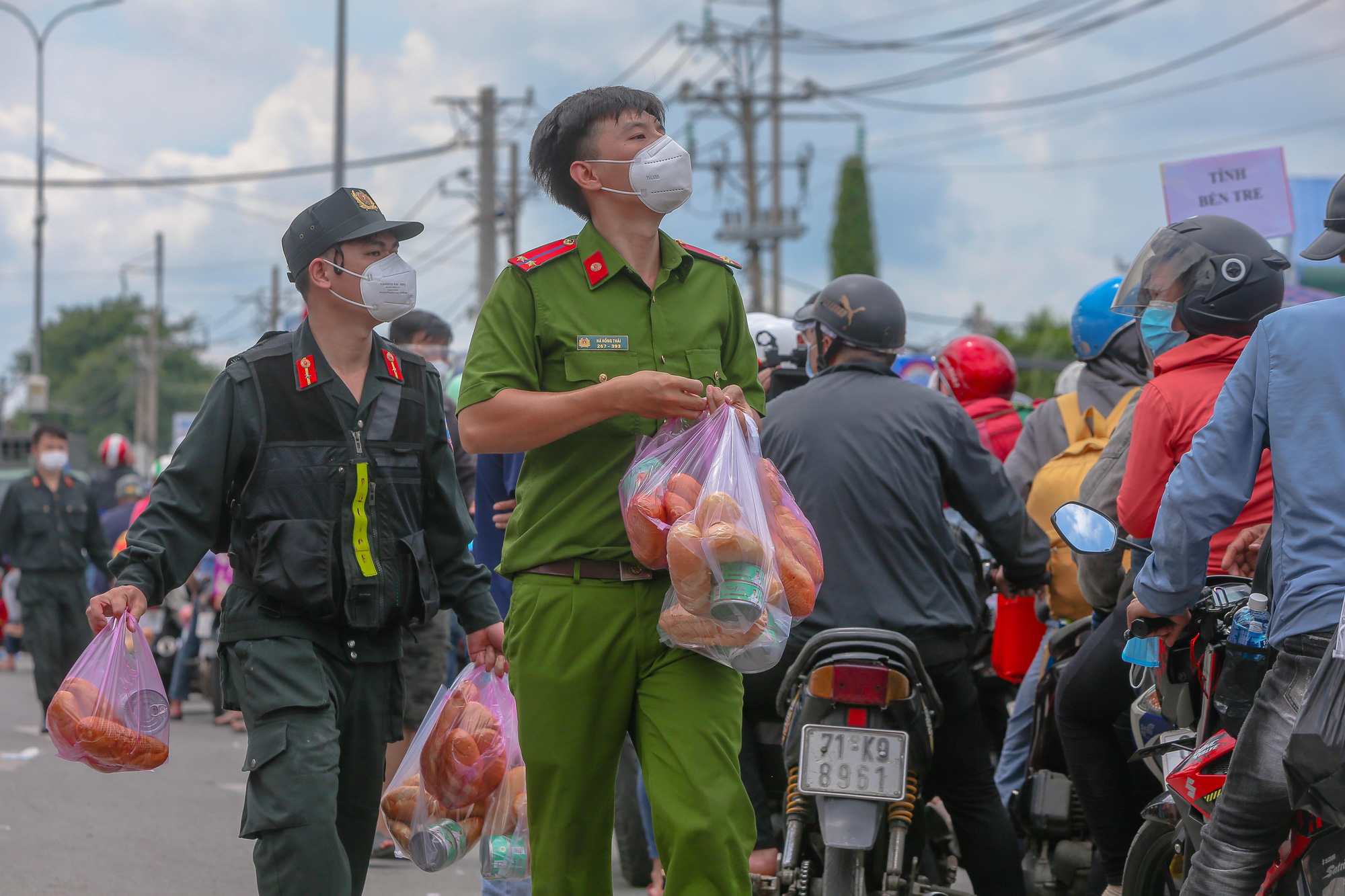 Qu&acirc;n đội, c&ocirc;ng an tặng thực phẩm, nước uống cho người d&acirc;n trước khi rời TP HCM về qu&ecirc; - Ảnh 2.
