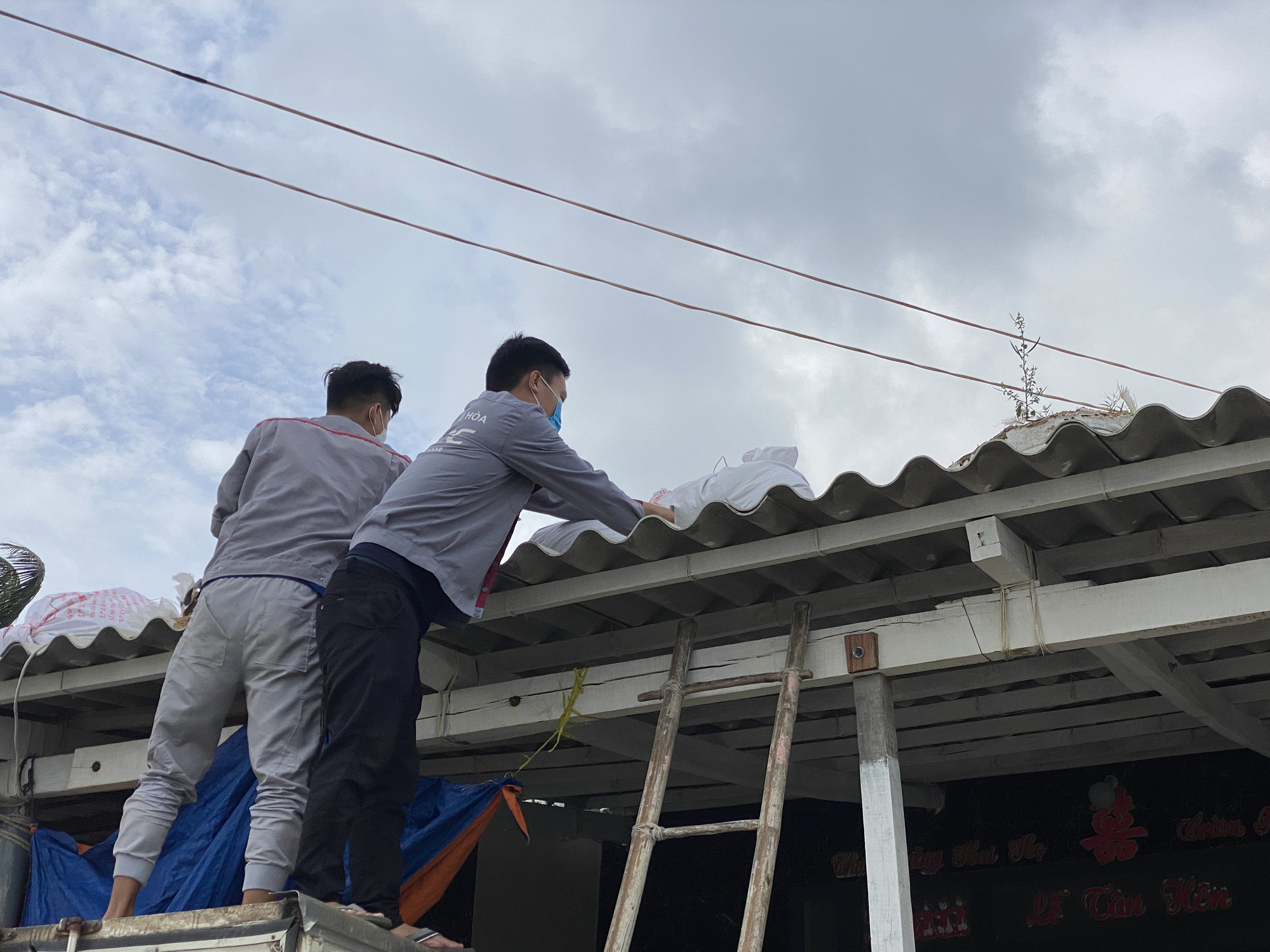 Lý Sơn có gió cấp 7-8, người dân chằng chống nhà cửa khi bão Rai đổ bộ - Ảnh 1.