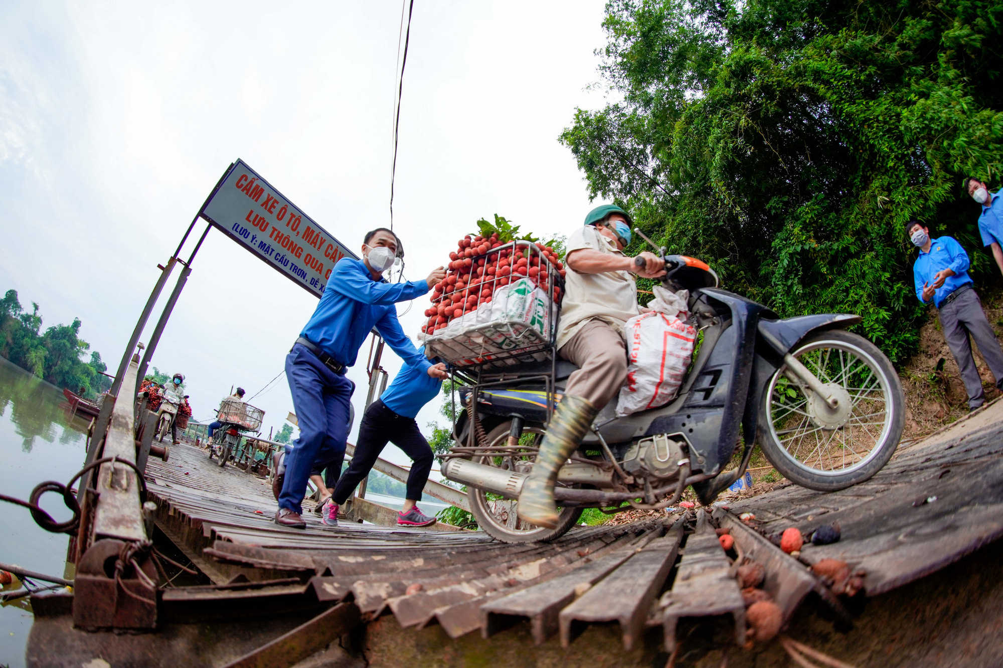 Cận cảnh n&ocirc;ng d&acirc;n chở vải th&oacute;t tim đi qua c&acirc;y cầu c&oacute; con dốc dựng đứng - Ảnh 2.