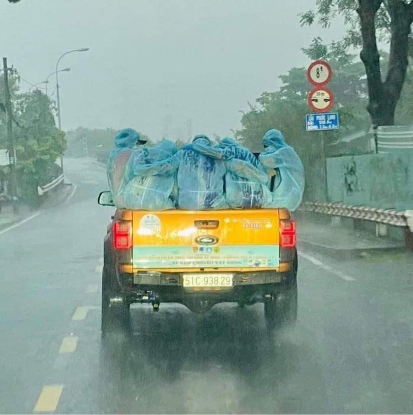 Đội phun xịt khử khuẩn choàng tay giữ ấm nhau dưới mưa - Ảnh 3.
