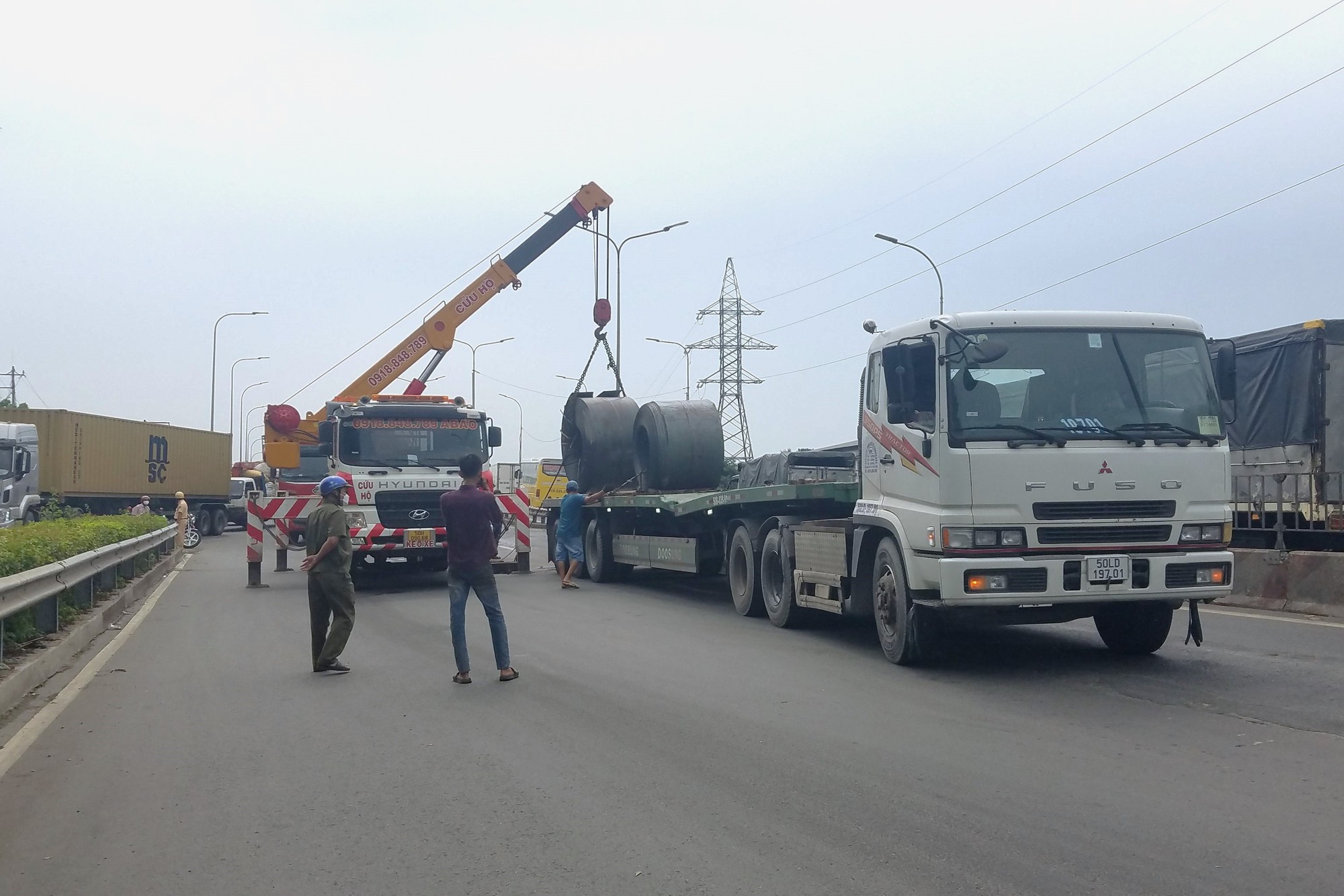 Hai cuộn sắt nặng hàng chục tấn đứt xích rơi xuống đường - Ảnh 1.