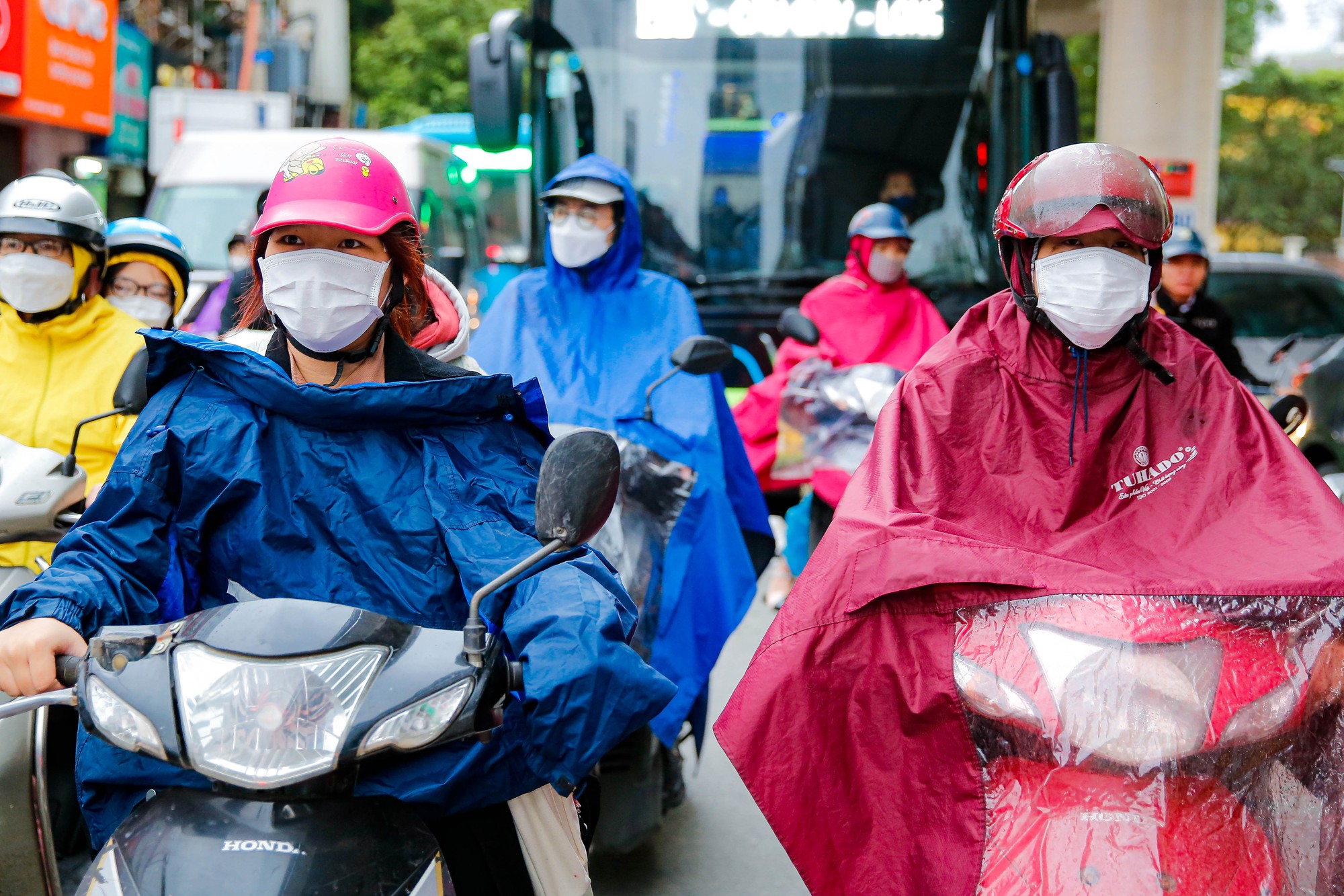 Người dân Hà Nội "trùm" áo mưa đón không khí lạnh