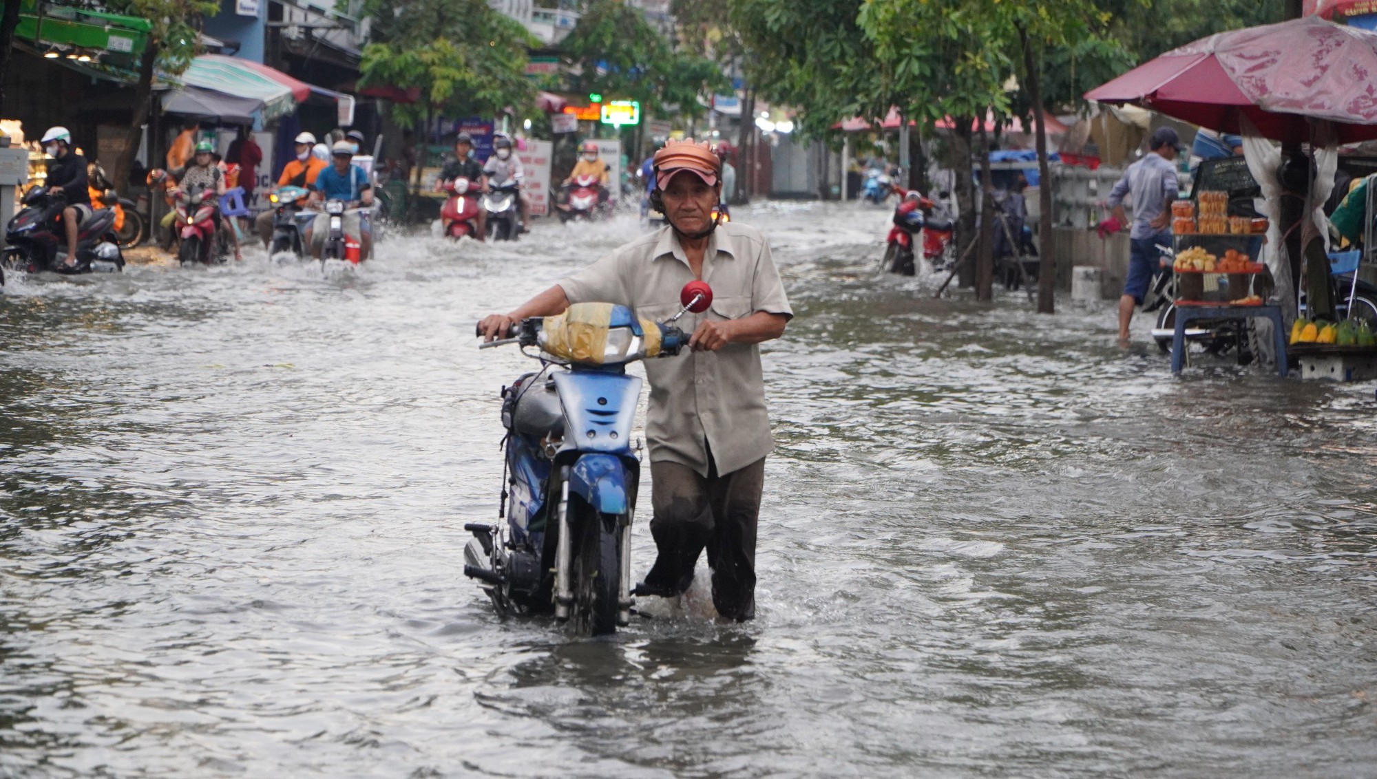 Loạt ảnh người d&acirc;n TP HCM h&igrave; hục dắt xe qua đoạn đường ngập ng&agrave;y triều cường d&acirc;ng cao - Ảnh 4.