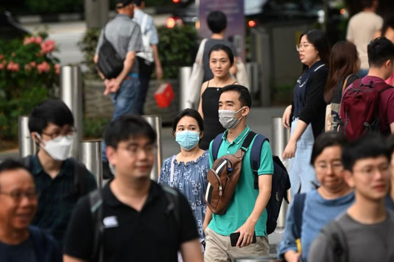 Người d&acirc;n Singapore được khuyến c&aacute;o đeo khẩu trang trong kh&ocirc;ng gian k&iacute;n đ&ocirc;ng người Ảnh: STRAITS TIMES