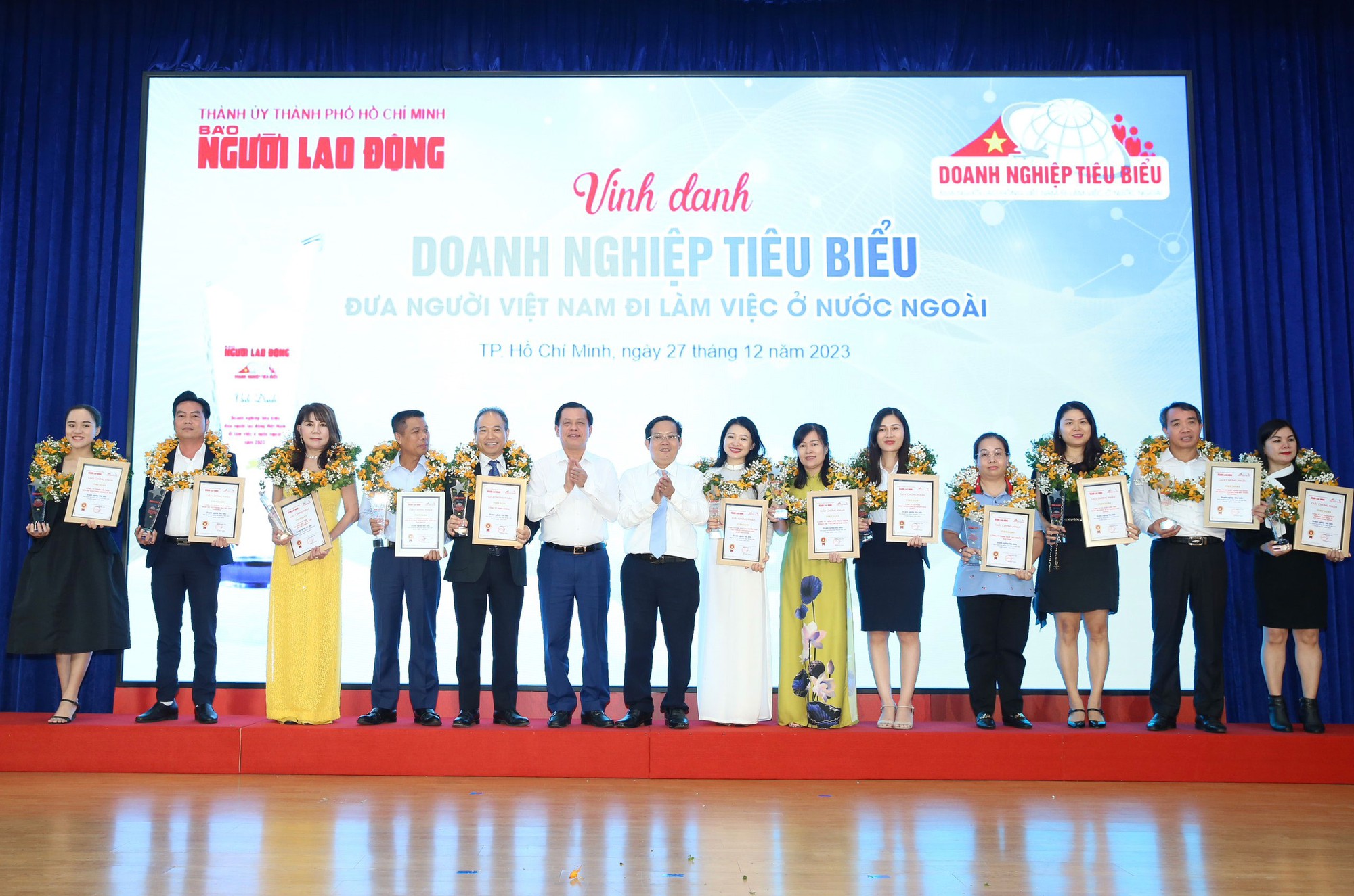 Ông Nguyễn Bá Hoan, Thứ trưởng Bộ Lao động - Thương binh và Xã hội và ông Tô Đình Tuân, Tổng Biên tập Báo Người Lao Động, chụp ảnh cùng 12 doanh nghiệp xuất khẩu lao động tiêu biểu