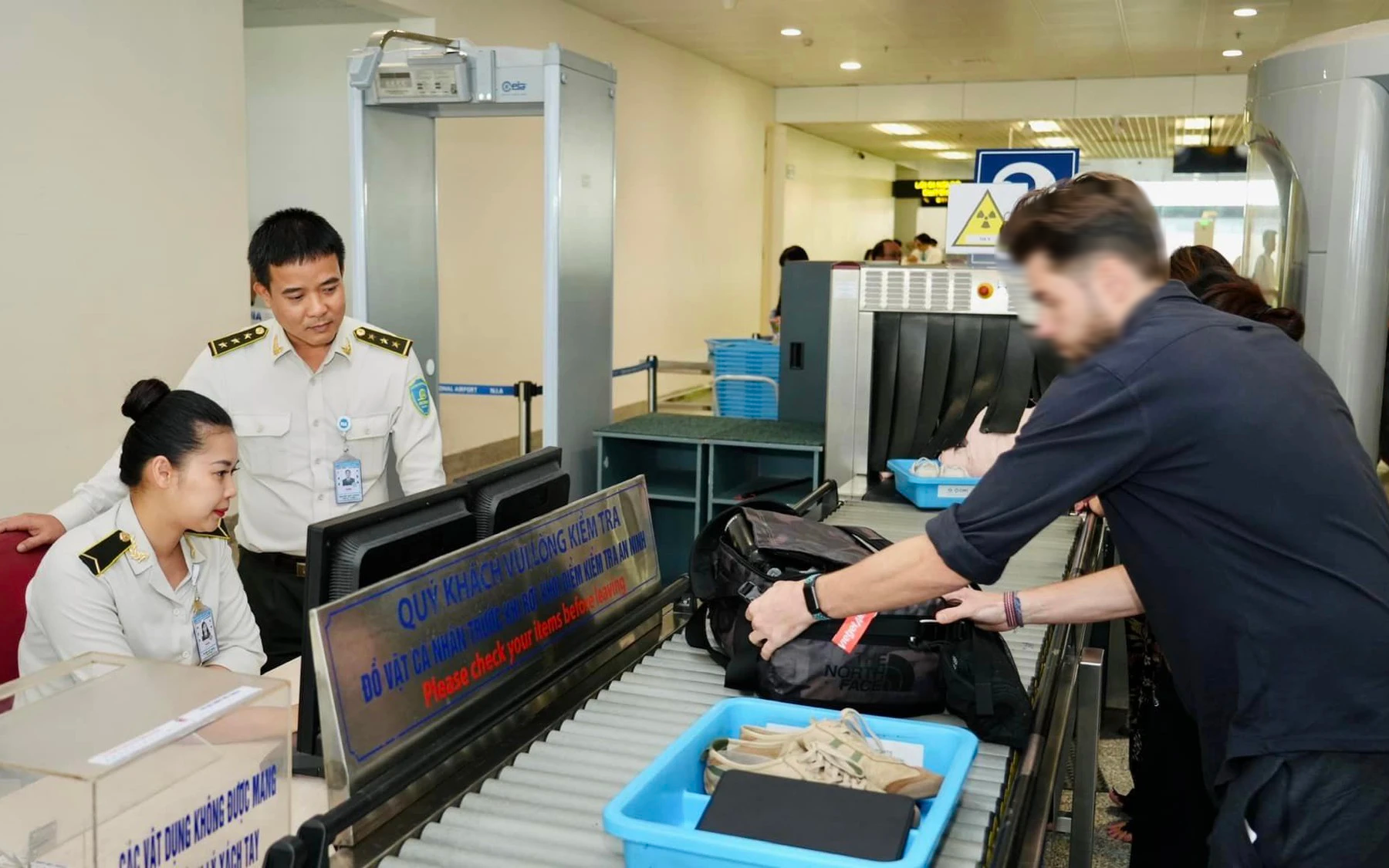 Khách đi sau nhanh tay nhặt đồng hồ của khách đi trước tại cửa an ninh
