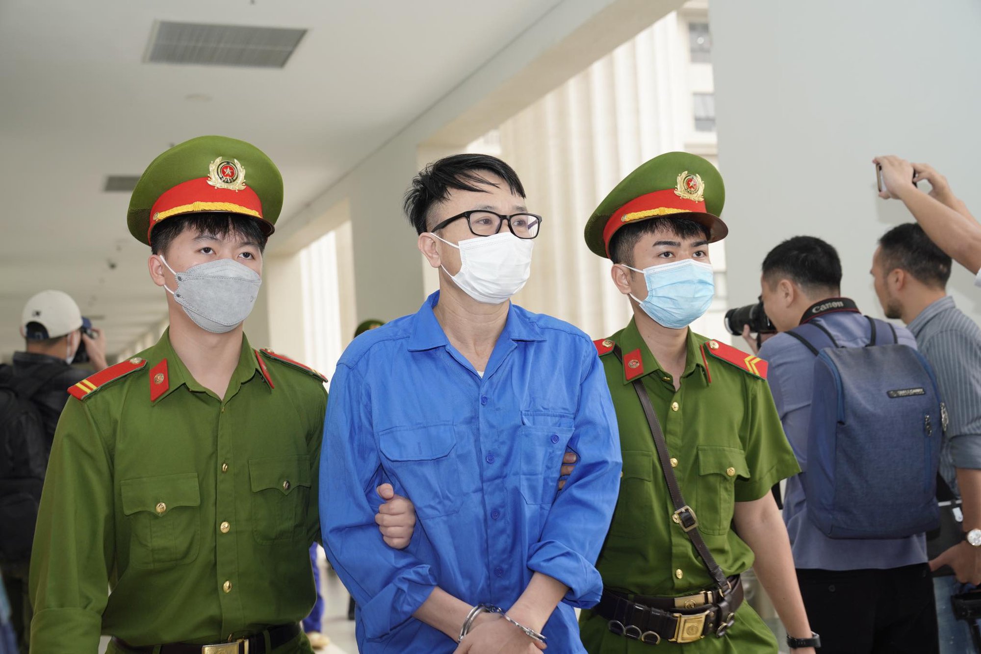 Cựu gi&aacute;m đốc BV Tim H&agrave; Nội Nguyễn Quang Tuấn mặc &aacute;o xanh tới t&ograve;a tr&ecirc;n xe đặc chủng - Ảnh 5.