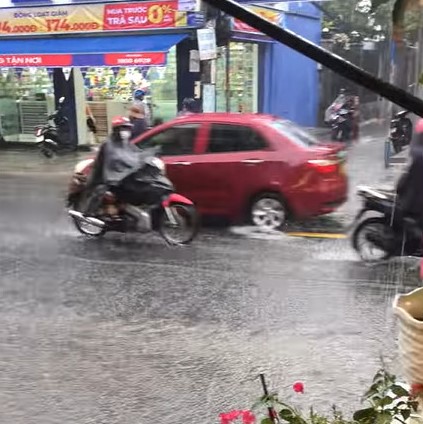 Cơn mưa v&agrave;ng đổ xuống TP HCM sau những ng&agrave;y n&oacute;ng đổ lửa - Ảnh 1.
