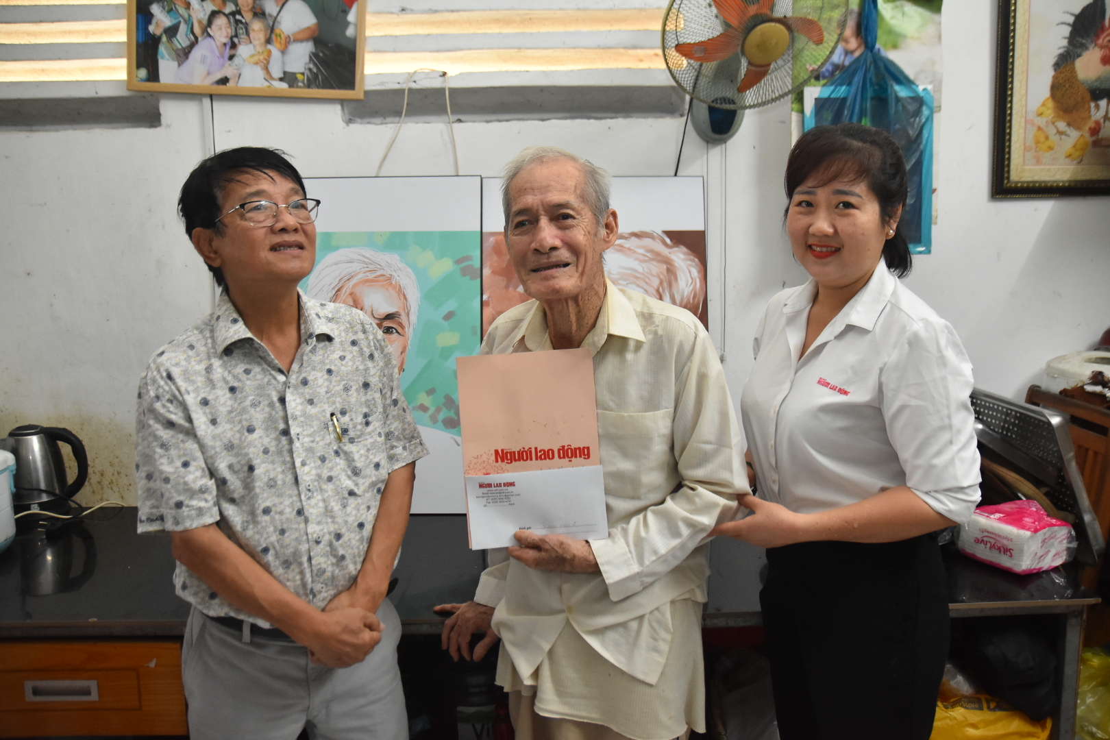 Vợ chồng cụ &ocirc;ng x&uacute;c động trước tranh v&agrave; qu&agrave; của B&aacute;o Người Lao Động c&ugrave;ng nh&agrave; b&aacute;o Huỳnh Dũng Nh&acirc;n - Ảnh 2.