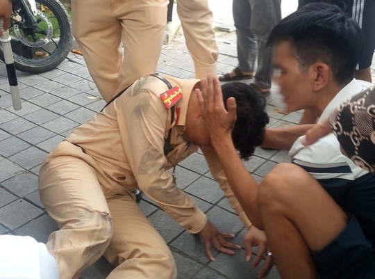 Qu&aacute;i xế vượt đ&egrave;n đỏ, t&ocirc;ng đại &uacute;y CSGT ng&atilde; trượt d&agrave;i tr&ecirc;n đường - Ảnh 1.