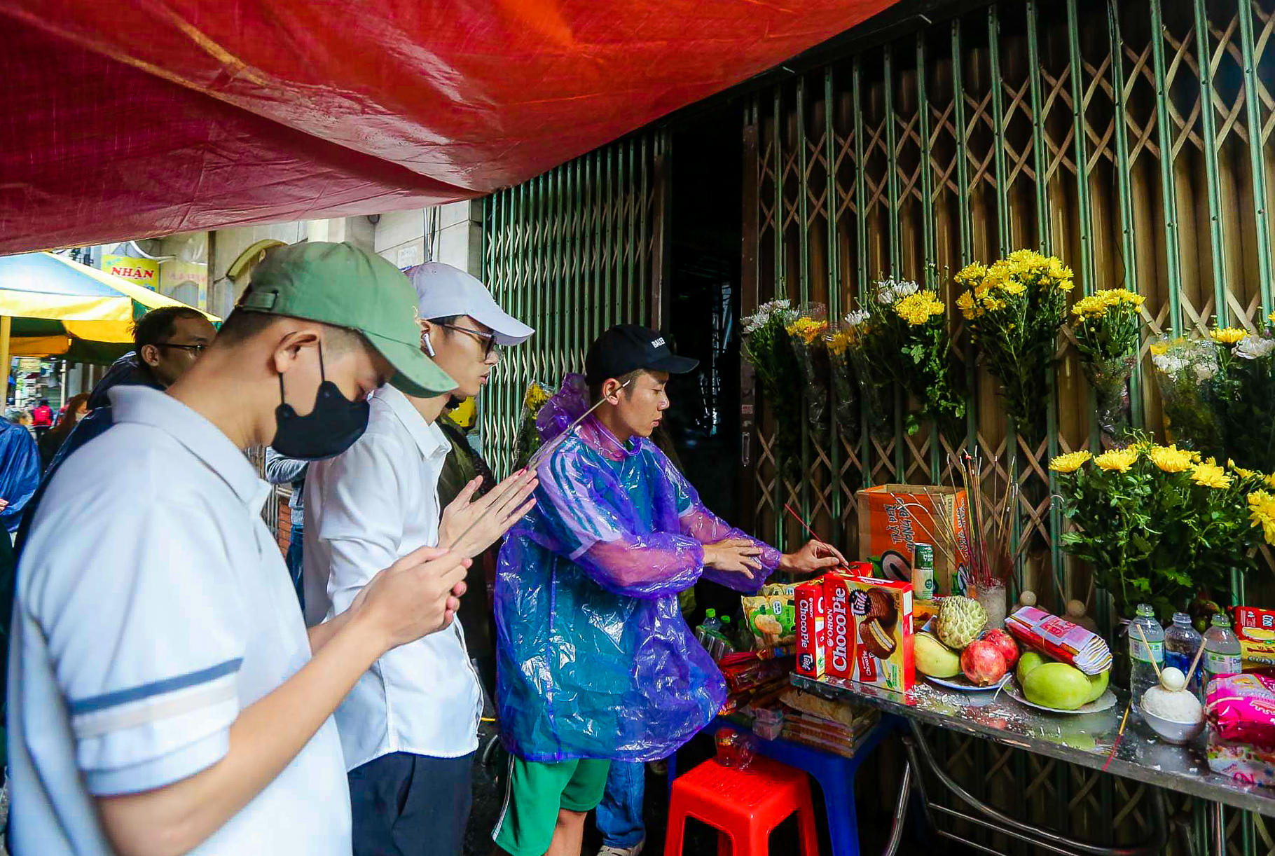 Người dân đội mưa tới thắp hương tưởng niệm các nạn nhân vụ cháy chung cư mini