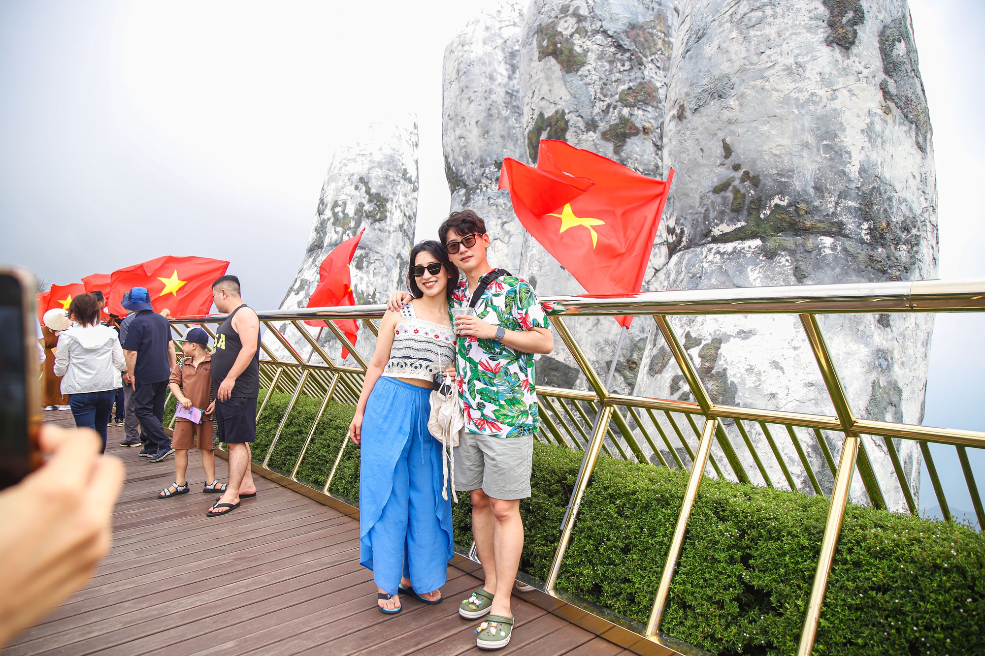 Khách thích thú với hình ảnh cờ Tổ quốc tung bay ở cầu Vàng - Đà Nẵng