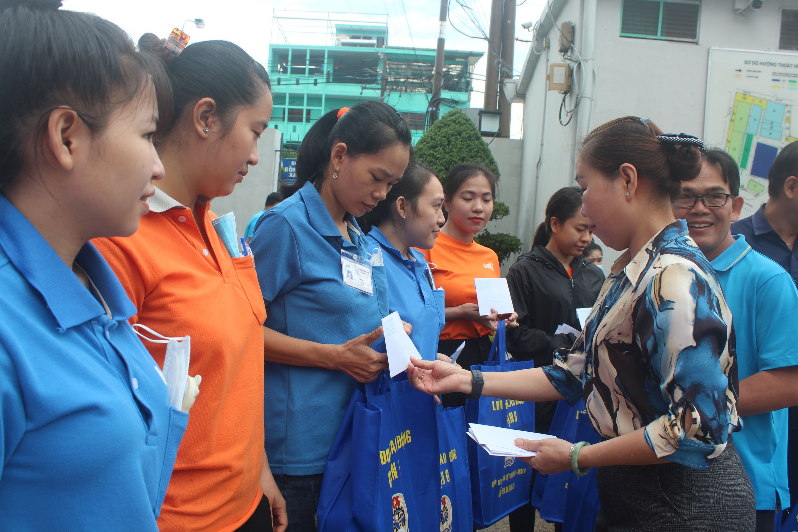 Đại diện Ban Giám đốc Công ty TNHH Sản xuất hàng tiêu dùng Bình Tiên tặng quà cho công nhân khó khăn. Ảnh: THANH NGA