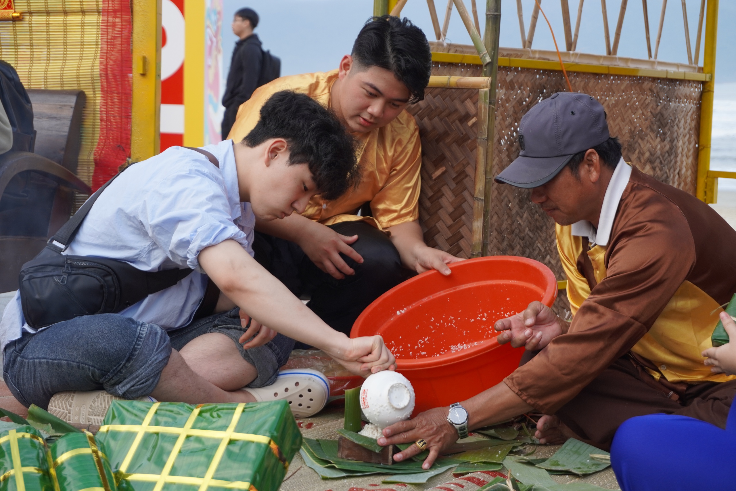 Du kh&aacute;ch nước ngo&agrave;i tập g&oacute;i b&aacute;nh chưng b&ecirc;n b&atilde;i biển Đ&agrave; Nẵng- Ảnh 1.