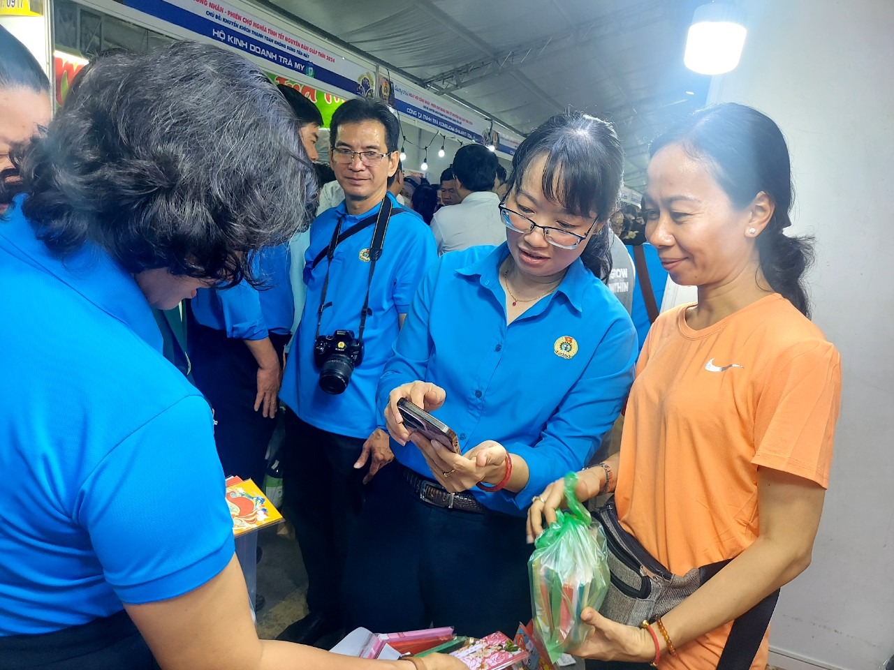 Bà Trần Thị Diệu Thúy, Chủ tịch LĐLĐ TP HCM (thứ hai từ phái sang), tham gia mua hàng không dùng tiền mặt tại "Ngày hội công nhân- Phiên chợ nghĩa tình" - Ảnh: MAI CHI