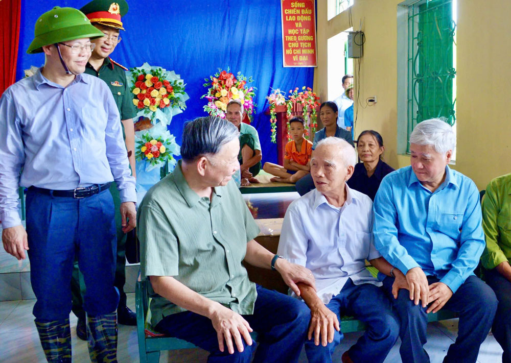 Tổng B&iacute; thư, Chủ tịch nước T&ocirc; L&acirc;m (ngồi b&igrave;a tr&aacute;i) v&agrave; Chủ tịch Ủy ban Trung ương MTTQ Việt Nam Đỗ Văn Chiến (b&igrave;a phải) thăm hỏi, động vi&ecirc;n người d&acirc;n bị ảnh hưởng bởi cơn b&atilde;o số 3 tại x&atilde; Trường Sinh, huyện Sơn Dương, tỉnh Tuy&ecirc;n Quang