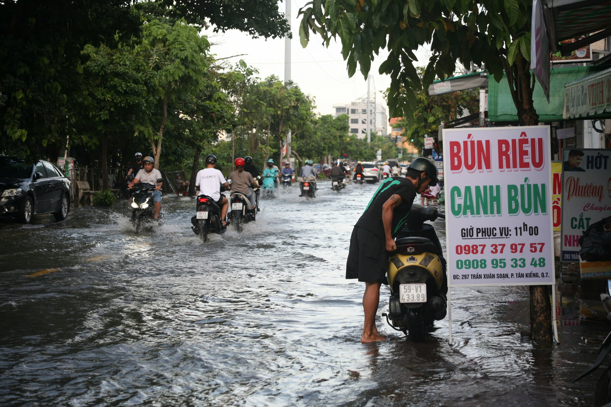 TP HCM: Triều cường dâng cao khiến đường sá ngập sâu, người dân vất vả đi lại- Ảnh 4.