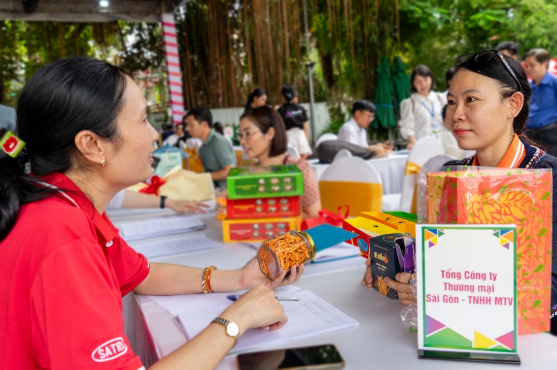 A person sitting at a table with a person in red shirt  Description automatically generated