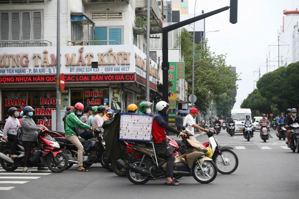 Hàng loạt xe máy chắn vạch kẻ dành cho người đi bộ khi chờ đèn đỏ trên đường Đinh Tiên Hoàng, quận 1, TP HCM. Ảnh: ÁI MY