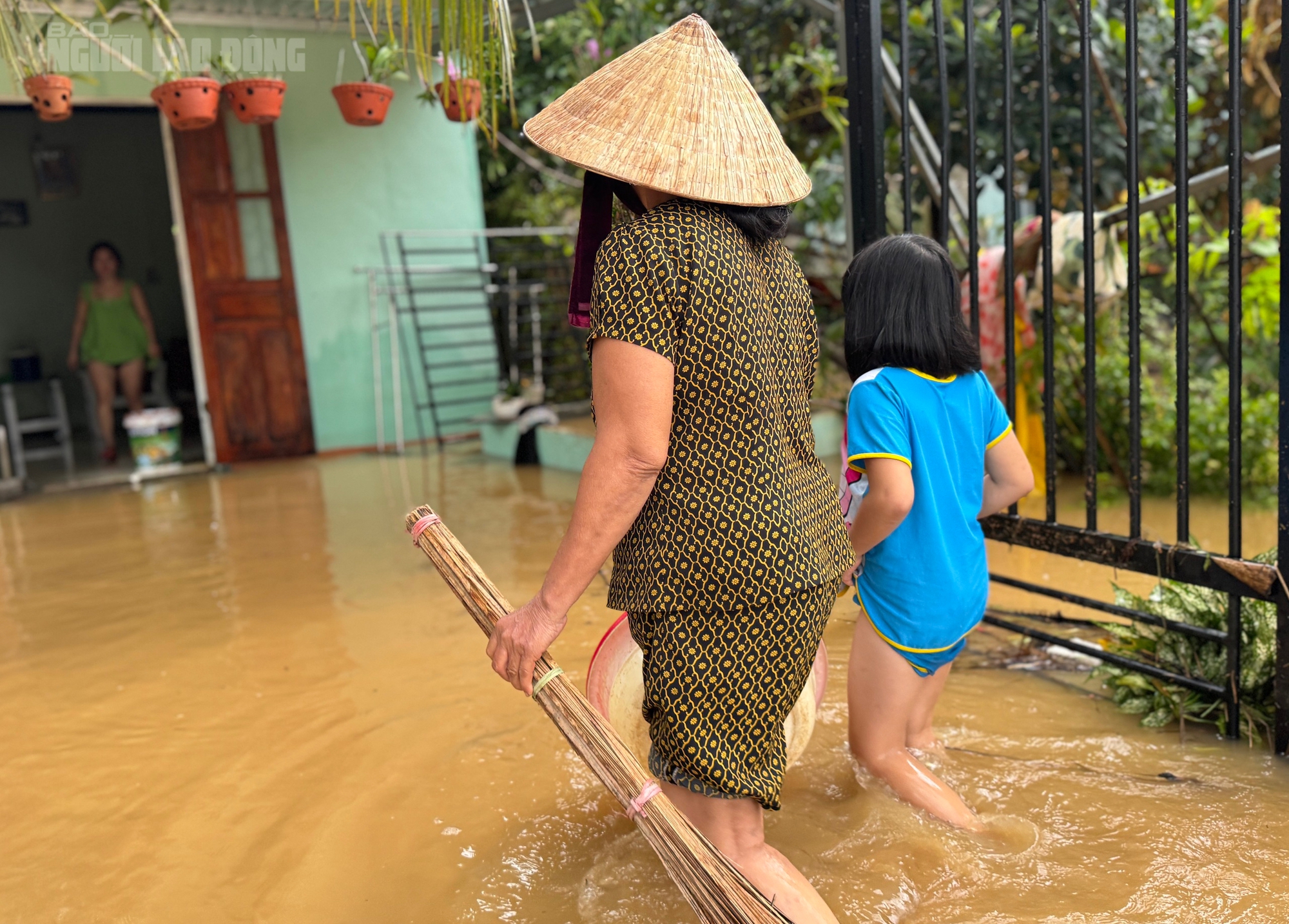 Đường thành sông, người dân Đà Nẵng “mượn” nước lũ để dọn nhà sau bão Trà Mi - Ảnh 1.
