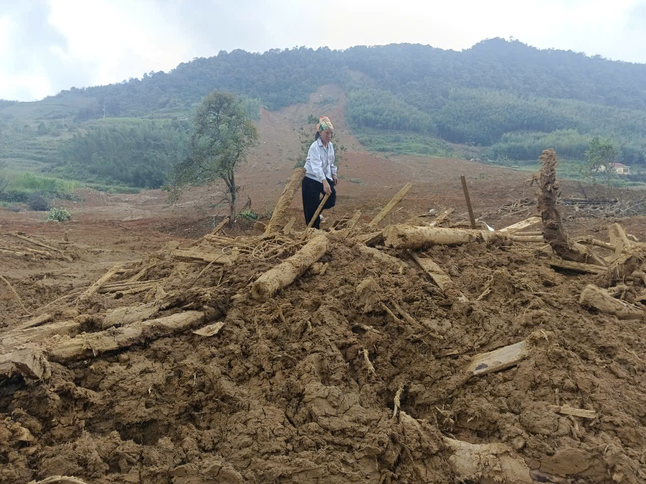 Một phụ nữ ở Lũng Lỳ (Cao Bằng) lục tìm tài sản dưới lớp đất đá sau vụ sạt lở hôm 9-9Ảnh: ĐỨC NGỌC