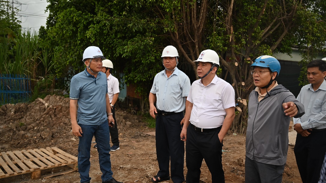 A group of men wearing hard hats Description automatically generated