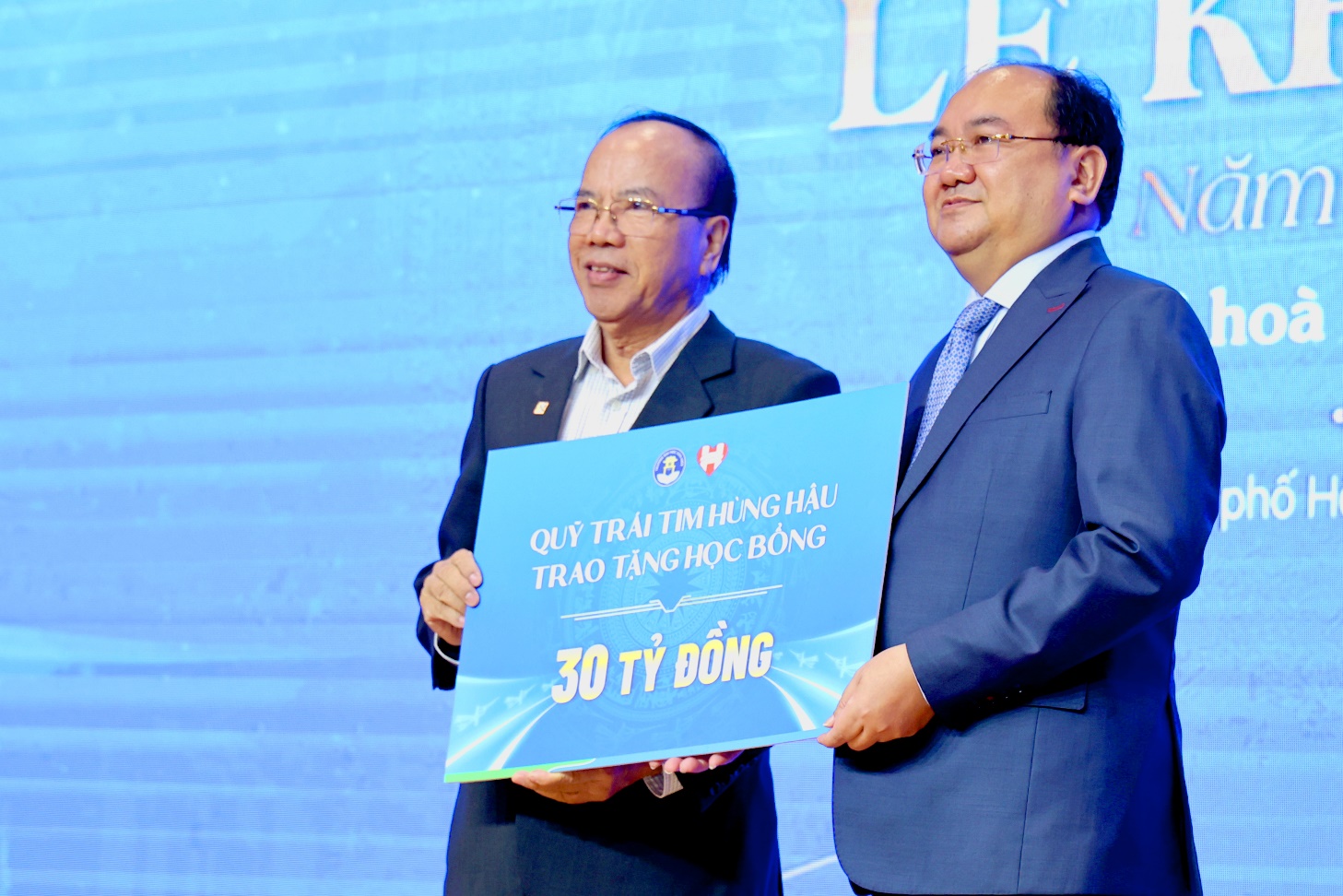Two men holding a sign Description automatically generated
