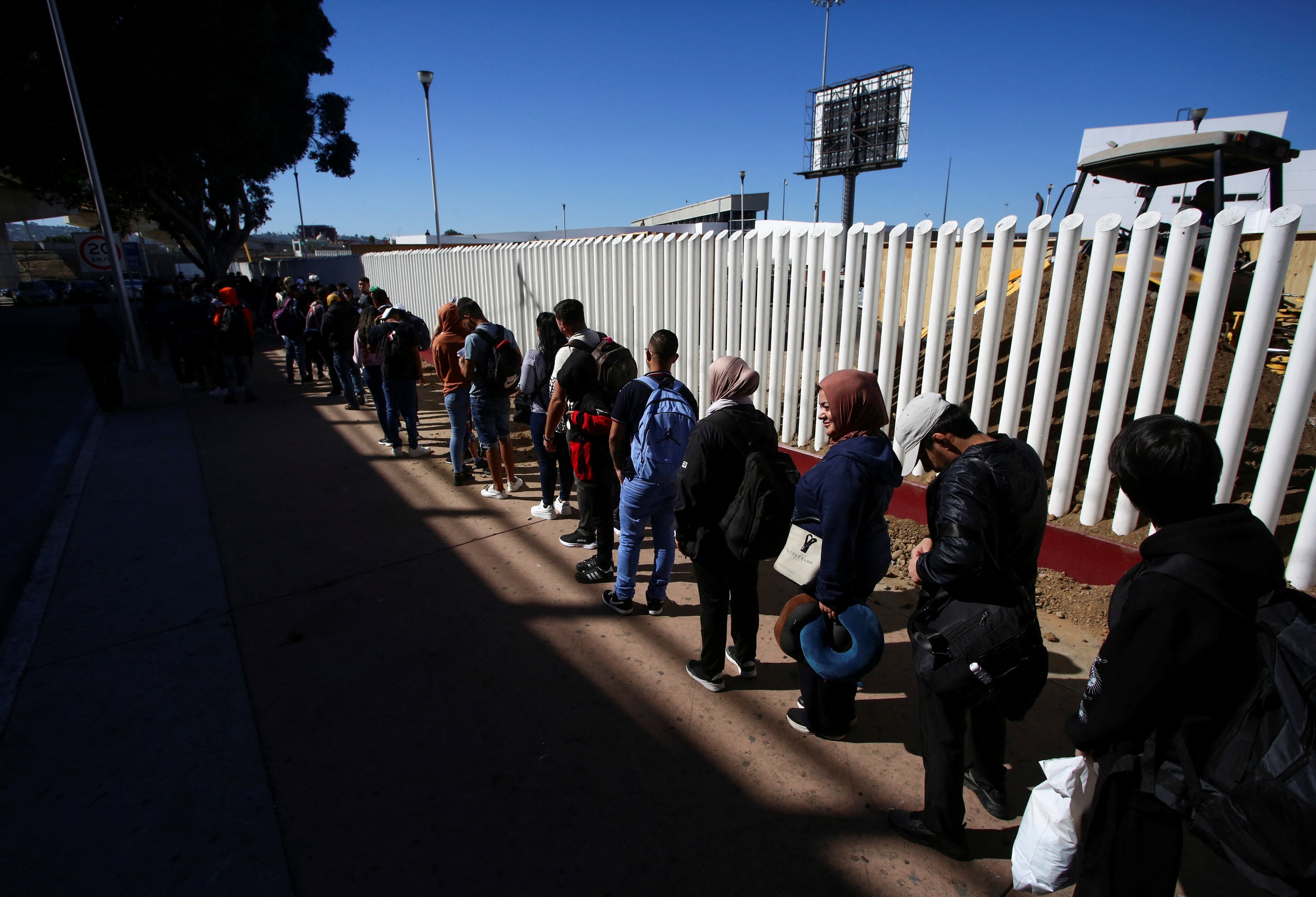 Người di cư xếp h&agrave;ng tại TP Tijuana - Mexico để kiểm tra giấy tờ trước khi nhập cảnh Mỹ h&ocirc;m 4-11. Tổng thống đắc cử Mỹ Donald Trump đ&atilde; cam kết trục xuất h&agrave;ng loạt người nhập cư khi c&ograve;n tranh cử Ảnh: Reuters