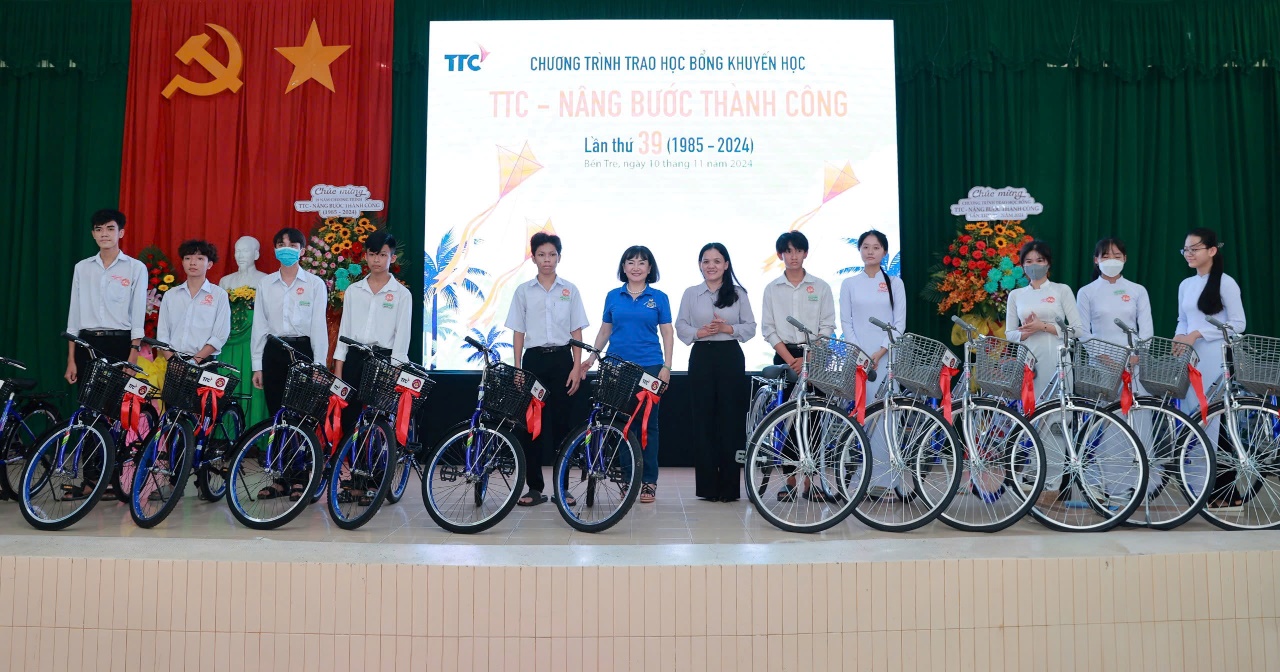 A group of people standing on a stage with bicycles Description automatically generated