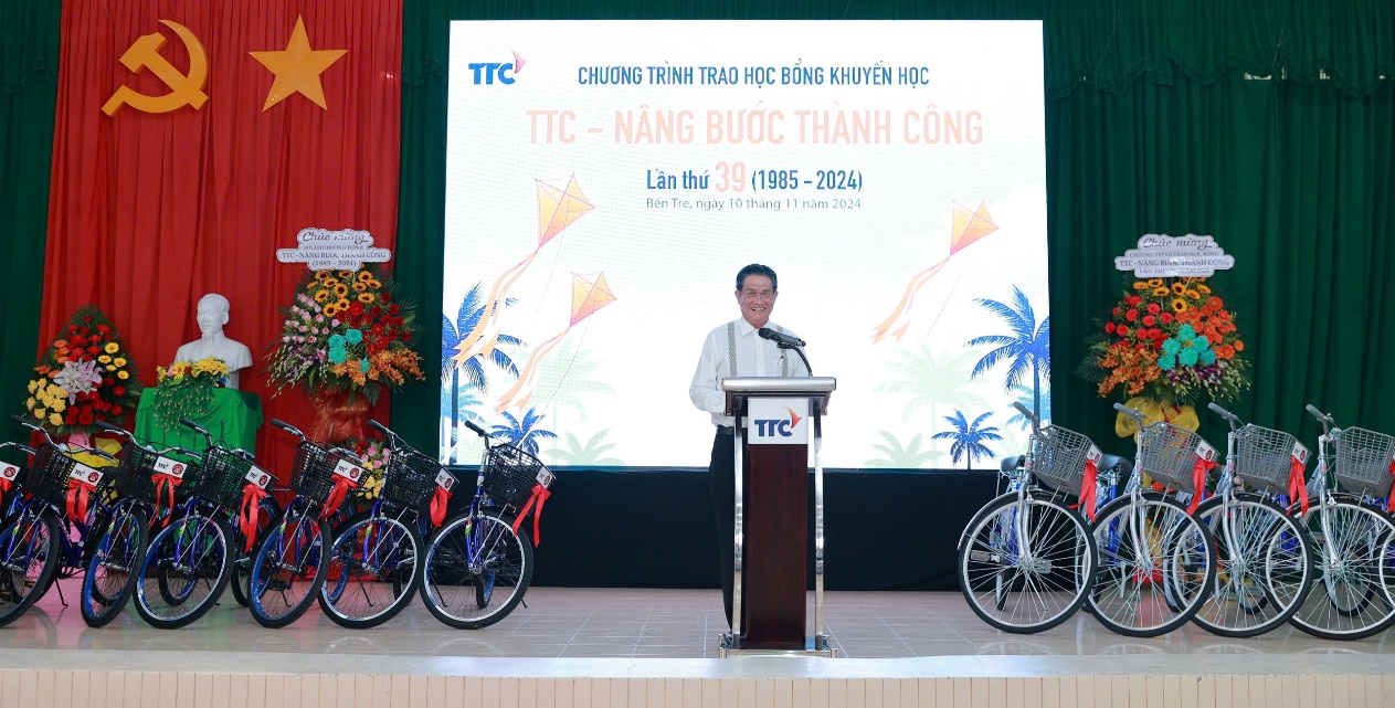 A person standing at a podium with a podium and bicycles on the side Description automatically generated