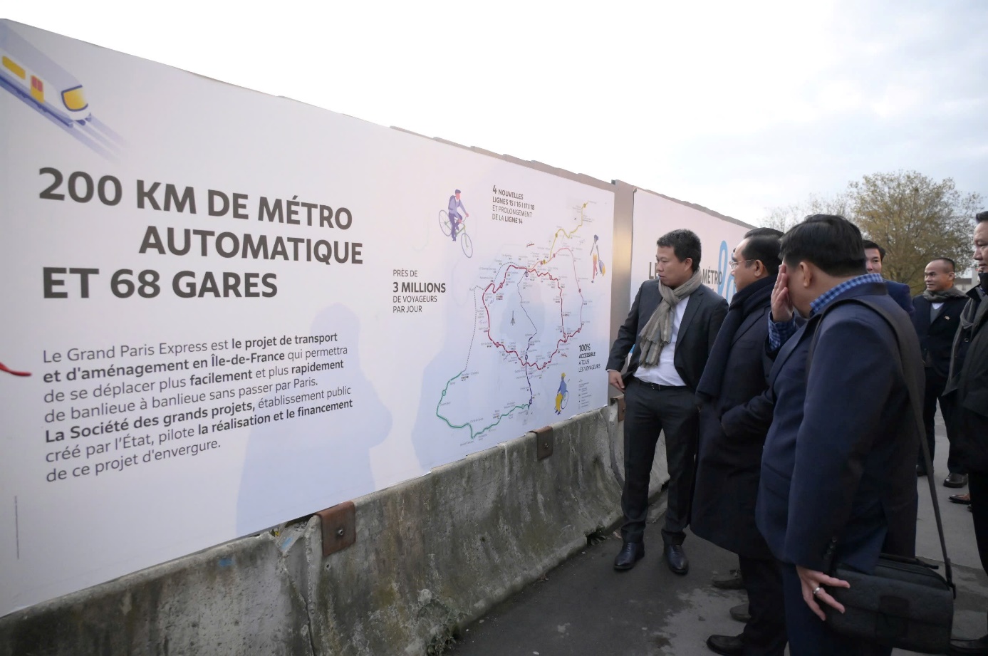 A group of men looking at a sign Description automatically generated