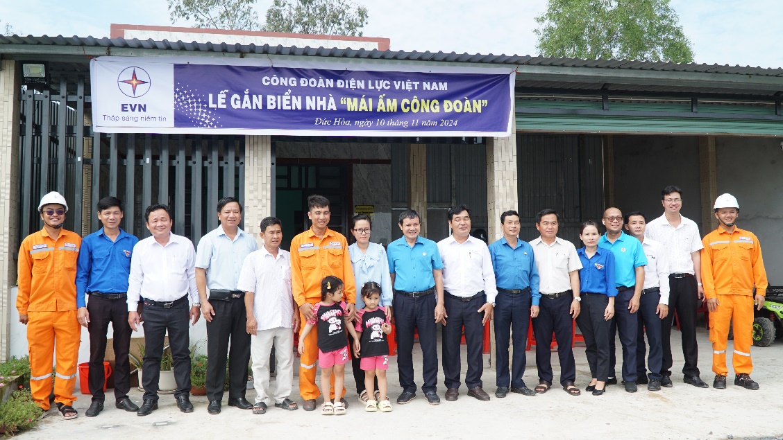 A group of people standing in front of a building Description automatically generated