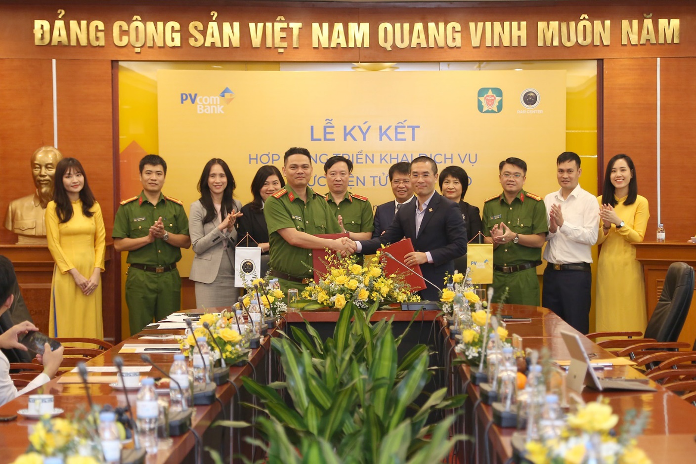 Thiếu t&aacute; Trần Duy Hiển, Ph&oacute; Gi&aacute;m đốc Trung t&acirc;m dữ liệu quốc gia về d&acirc;n cư, Gi&aacute;m đốc Trung t&acirc;m RAR v&agrave; &ocirc;ng Nguyễn Việt H&agrave;, Ph&oacute; Tổng Gi&aacute;m đốc PVcomBank k&yacute; kết hợp đồng triển khai dịch vụ x&aacute;c thực điện tử qua VNeID