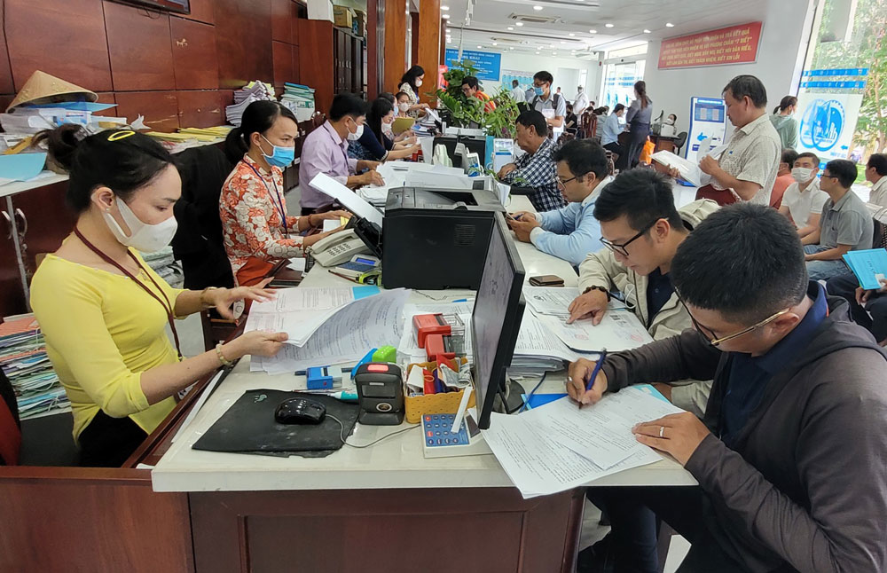 C&aacute;n bộ, c&ocirc;ng chức UBND huyện B&igrave;nh Ch&aacute;nh, TP HCM giải quyết thủ tục h&agrave;nh ch&iacute;nh cho người d&acirc;n. Ảnh: TẤN THẠNH