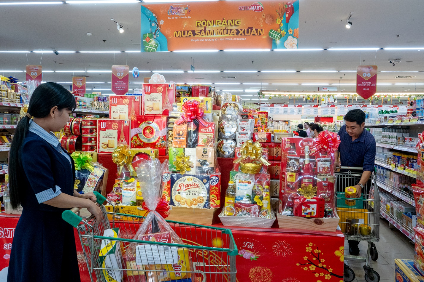 People in a store with a variety of products Description automatically generated