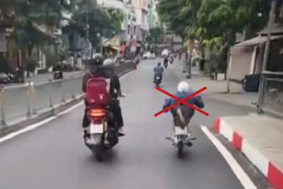Thanh niên nằm trên yên xe máy chạy trên đường trung tâm TP HCM- Ảnh 1.