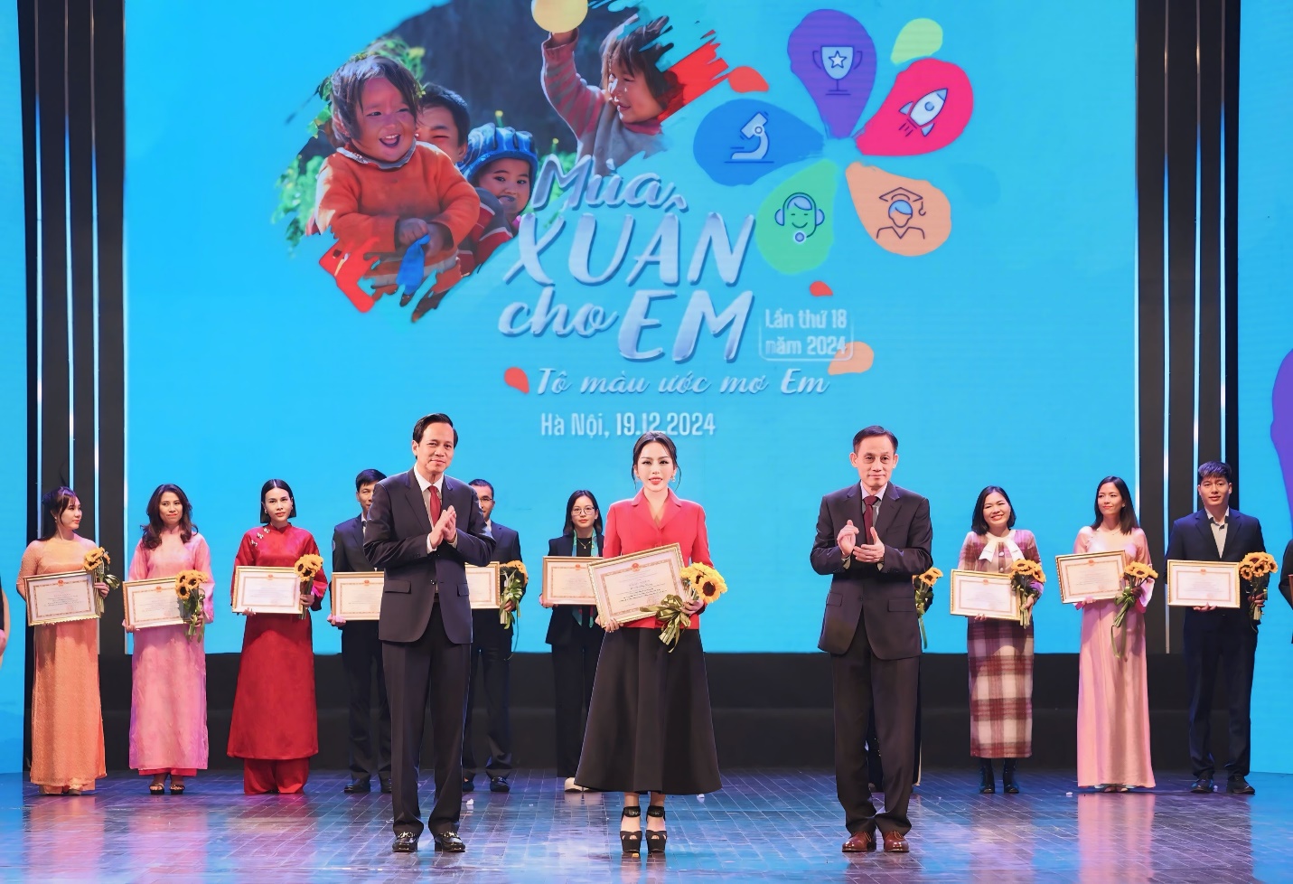 A group of people on a stage Description automatically generated