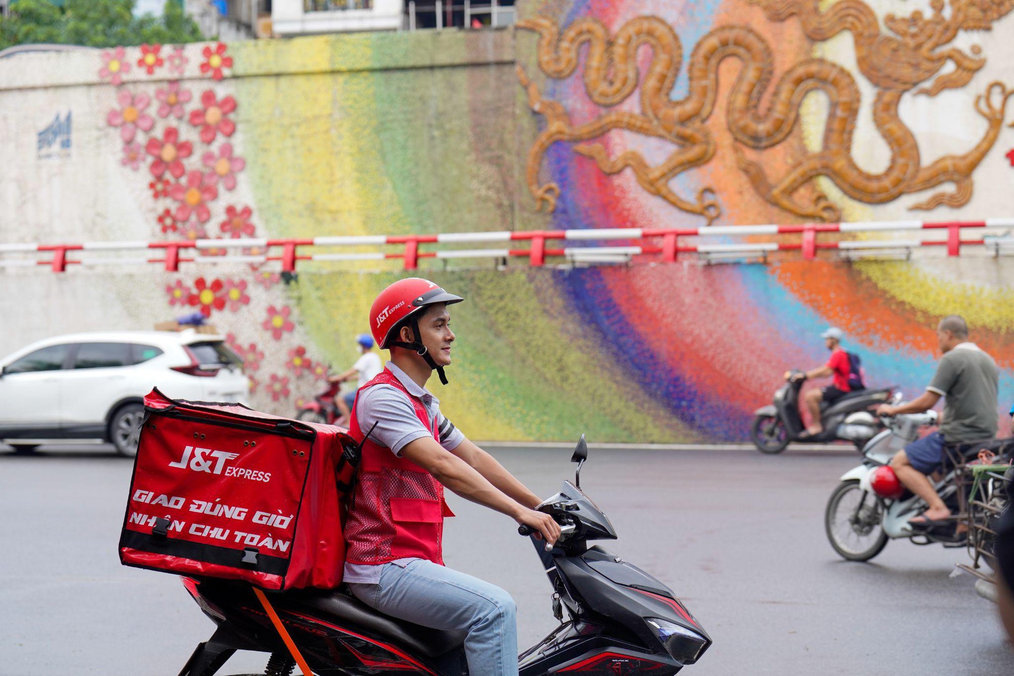 A person riding a scooter with a food delivery box  Description automatically generated